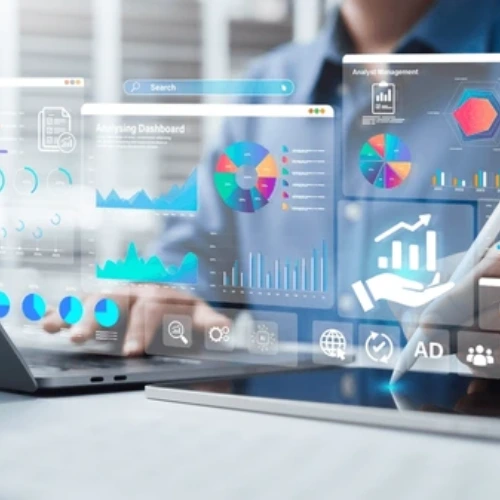 A person working on a laptop and tablet with floating digital dashboards showing charts, analytics, customer data, and marketing performance metrics